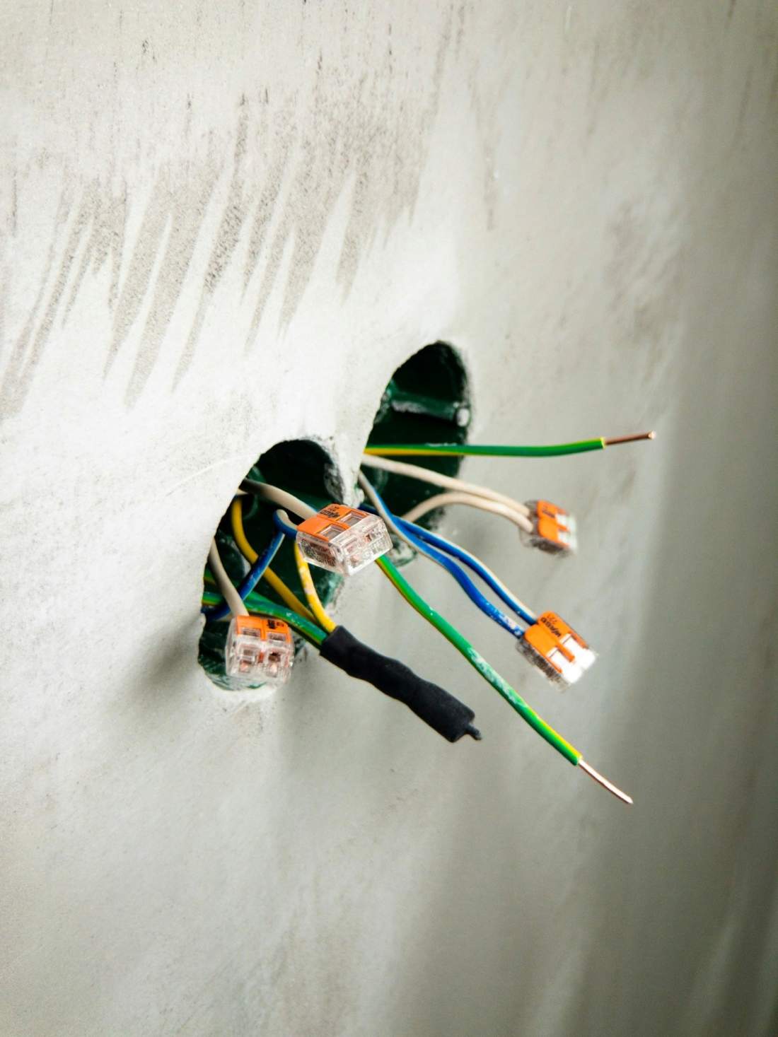 Hand holding a bundle of blue network cables during a low-voltage rough-in