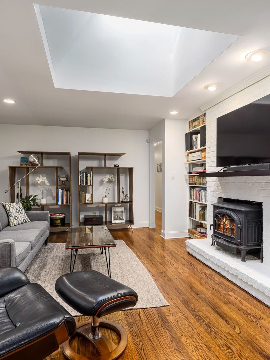 Traditional living room with a TV mounted above a fireplace and built-in shelving